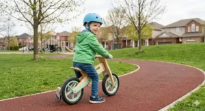 Preschooler practicing coordination on a wooden balance bike at a local Canadian community park in April.