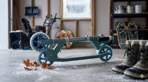 A quality 2 wheel scooter for kids neatly folded and stored in a garage during a Canadian winter season.