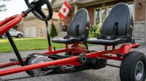 Two siblings cooperating and steering a 2 seater pedal go kart for kids during a sunny afternoon in a Canadian driveway.