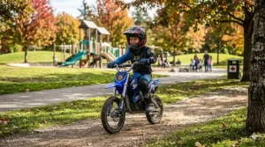 Young child riding an electric dirt bike for kids at a local park.