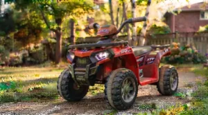 Child's hands on the steering wheel of a 6v ride on atv for kids. / Mains d'un enfant sur le volant d'un VTT électrique 6v pour enfants.