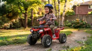 Child playing on a 6v ride on atv for kids in a local park. / Enfant jouant sur un VTT électrique 6v pour enfants dans un parc local.