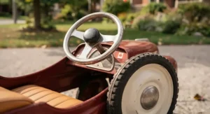 Close-up shot of authentic chrome steering wheel and rubber tires on a tested classic pedal car model.