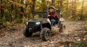 A heavy-duty 24v power wheels vehicle navigating a gravel path, ideal for active older kids in Canada.