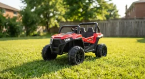 Bright red kids electric off-road vehicle parked on green grass during a sunny summer day