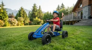 A child riding a sporty blue pedal go-kart for kids across a lush green backyard lawn in British Columbia.