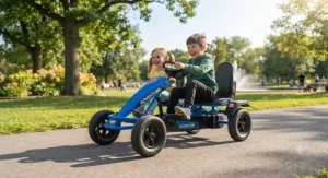 Two children steering a bright blue two-seater pedal go-kart for siblings on a smooth pavement path.
