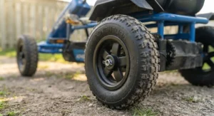 Detail view of the robust rubber tires on a two-seater pedal go-kart for siblings built for all-terrain play.