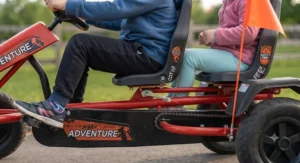 Close-up illustration showing the adjustable seats and safety features of a two-seater pedal go-kart for siblings.